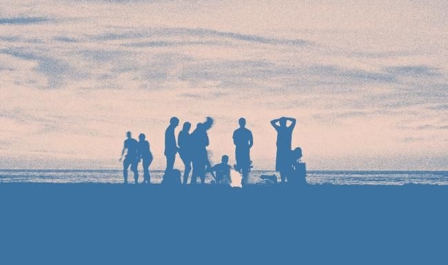a group of people standing on a beach